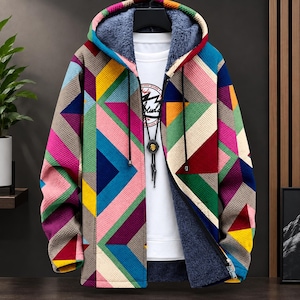 Puede incluir: Una chaqueta con capucha y cremallera que presenta un vibrante patrón geométrico de triángulos y rayas en tonos rosa, amarillo, azul, verde y morado. El interior está forrado con un material polar gris oscuro e incluye cordones negros.