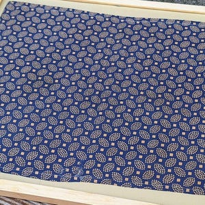 May include: A framed blue and gold patterned fabric with a paisley design.