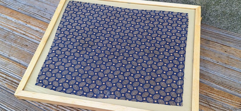 May include: A framed blue and gold patterned fabric with a paisley design.