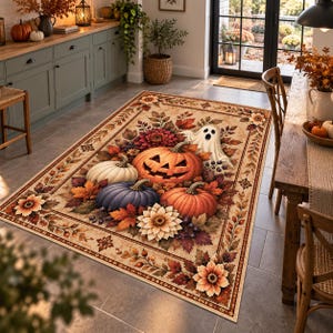 May include: A rectangular area rug featuring a central design of a carved jack-o'-lantern, a white ghost, and various pumpkins in orange, white, and blue. The rug is decorated with autumn leaves, flowers, and a border of foliage patterns.