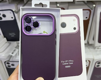 Puede incluir: Una funda de teléfono de color morado oscuro con un marco de cámara morado metálico, presentada en una caja blanca con la etiqueta For iP17Pro Leather Case. La funda tiene un recorte para las lentes y se muestra junto a otras cajas.