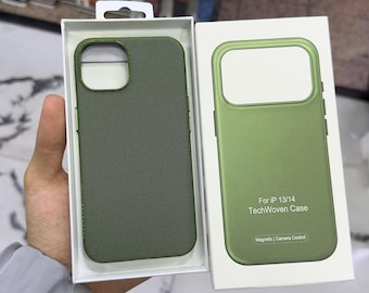 Puede incluir: Una funda de teléfono texturizada de color verde oliva para IP 13/14 en un empaque blanco. La caja presenta el texto For IP 13/14 TechWoven Case y Magnetic | Camera Control. La funda tiene una superficie tejida y un recorte rectangular.