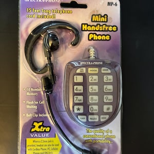 May include: A Spectra-Phone MP-6 mini handsfree phone in original packaging. The set includes a black ear-hook headset and a purple keypad unit with 15 feet of telephone cord. Features include 10 number memory, flash for call waiting, and a belt clip.