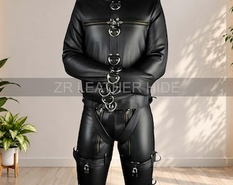 May include: A black leather full-body suit featuring a high collar, long sleeves, and a vertical strap with multiple metal D-rings down the chest. The garment includes integrated trousers with leg straps, padlocks, and zippers. Text reads ZR LEATHER HIDE.