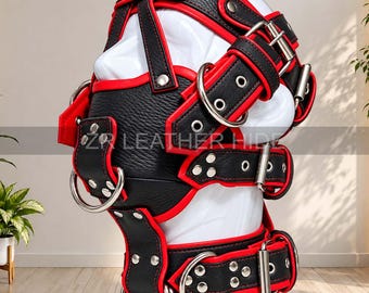 May include: A black and red leather head harness featuring multiple adjustable straps, silver-toned metal buckles, and large O-rings. The headgear is displayed on a white mannequin head and includes the text ZR LEATHER HIDE.