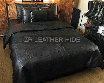 May include: A black leather bed set featuring a large duvet cover and five matching pillows. The surface of the bedding is composed of stitched leather panels. The text ZR LEATHER HIDE is printed in white across the centre of the duvet cover.