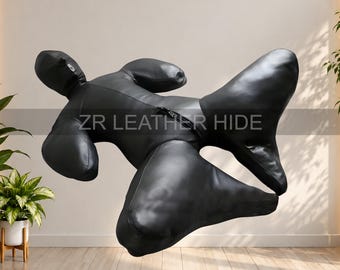 May include: A black leather full-body suit with a hood and long sleeves, featuring a central zip closure. The text ZR LEATHER HIDE is printed across the midsection of the garment, which is displayed in a dynamic, suspended pose.