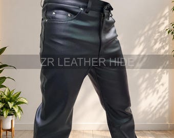 May include: Black leather trousers featuring a classic five-pocket design with silver-toned rivets, a front zip fly, and belt loops. The text ZR LEATHER HIDE is printed across the centre of the trousers in a clear, sans-serif font.
