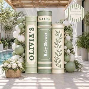 May include: Three large cylindrical book-shaped party cutouts in sage green and cream. The left cutout reads OLIVIA'S, the center reads Baby Shower and 6.14.26, and the right features a botanical vine print. Balloons and greenery surround the base.
