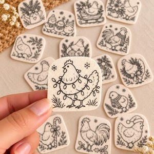 May include: A collection of small, square, off-white fabric patches featuring black line art illustrations of chickens in various holiday-themed scenes, including chickens with Christmas lights, scarves, Santa hats, candy canes, and winter foliage.