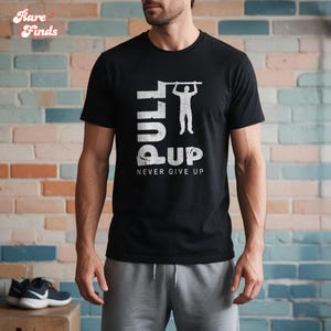 Può includere: Una t-shirt nera a maniche corte con una stampa grafica bianca di una persona che esegue una trazione alla sbarra. Il testo PULL UP è visualizzato in grandi lettere, con la frase NEVER GIVE UP stampata in caratteri bianchi più piccoli.