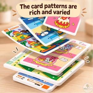 May include: A stack of rectangular educational cards featuring colorful cartoon illustrations of cakes, castles, and animals. The top card displays the text 'The card patterns are rich and varied'. Each card has a white border and a flat, smooth surface.