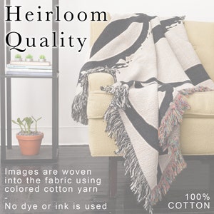 K&ouml;nnte beinhalten: Eine cremefarbene Decke mit einem schwarzen abstrakten Design ist &uuml;ber einem gelben Sessel drapiert. Die Decke hat Fransen mit bunten F&auml;den. Der Text "Heirloom Quality" wird oben links angezeigt. Der Text "100% COTTON" wird unten rechts angezeigt.