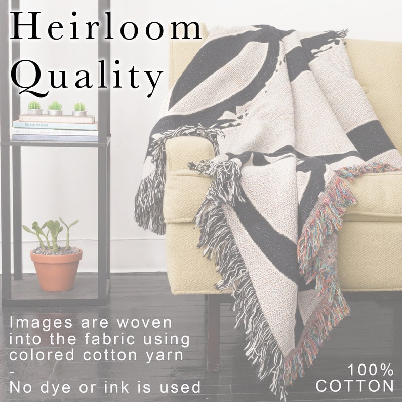 K&ouml;nnte beinhalten: Eine cremefarbene Decke mit einem schwarzen abstrakten Design ist &uuml;ber einem gelben Sessel drapiert. Die Decke hat Fransen mit bunten F&auml;den. Der Text "Heirloom Quality" wird oben links angezeigt. Der Text "100% COTTON" wird unten rechts angezeigt.