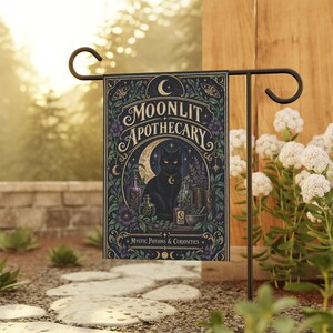 Peut inclure: Un drapeau de jardin rectangulaire illustrant un chat noir assis devant un croissant de lune, entouré de flacons de potions, d'herbes et de fleurs. Le texte indique Moonlit Apothecary et Mystic Potions & Curiosities en police décorative.