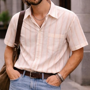 Op de afbeelding: Set van drie keramische mokken met een gespikkelde, matte afwerking. Elke mok heeft een andere kleur: lichtblauw, crème en grijs. De mokken hebben een eenvoudig, modern ontwerp en een comfortabele handgreep.