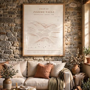 Può includere: Una stampa artistica incorniciata intitolata FIELD III PODERE VALLE MONTEPULCIANO TOSCANA 260M, che mostra un disegno topografico a linee di un paesaggio con colline e vigneti in tonalità marroni su sfondo crema, in una cornice di legno chiaro.