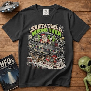 May include: A black t-shirt featuring a graphic print of Santa Claus piloting a flying saucer with green aliens. The text reads SANTA TOOK A WRONG TURN. Below, reindeer look at an empty sleigh on a snowy rooftop with a sign that says SAME ROOFTOP DIFFERENT GALAXY.