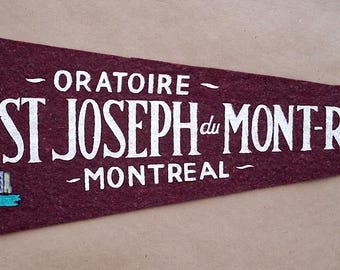 Könnte beinhalten: Burgunderfarbener Filz-Wimpel mit einer Illustration des St. Josephs Oratoriums in Montreal. Der Wimpel trägt den weißen Schriftzug "ORATOIRE ST JOSEPH du MONT-ROYAL MONTREAL" und blaue Bänder.