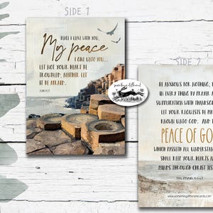 May include: Two-sided art print with inspirational quotes. Side 1 features "My peace I give unto you..." with a landscape image. Side 2 has "The Peace of God" with a coastal scene. Includes a logo with a rabbit.