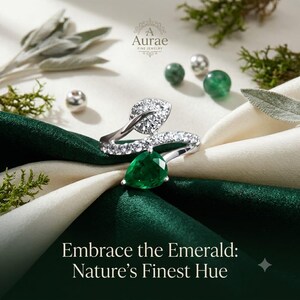 May include: A silver ring featuring a pear-shaped green gemstone and a leaf-shaped accent encrusted with clear stones. The ring is displayed with the text A Aurae Fine Jewelry and Embrace the Emerald: Nature's Finest Hue visible in the image.