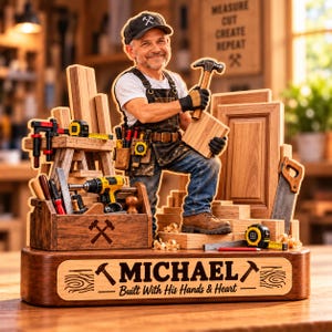 Könnte beinhalten: Eine Holzfigur eines Tischlers mit Kappe, weißem T-Shirt und Schürze, der einen Hammer und einen Holzblock hält. Der Sockel ist mit dem Namen MICHAEL und dem Text Built With His Hands & Heart graviert, umgeben von verschiedenen Werkzeugen.