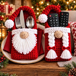 Könnte beinhalten: Zwei rote Häkeltaschen in Form von Weihnachtsmann und Weihnachtsfrau. Die Weihnachtsmann-Tasche enthält eine silberne Gabel, ein Messer und einen Löffel. Die Weihnachtsfrau-Tasche enthält zwei schwarze Fernbedienungen mit weißen Zöpfen.