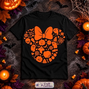 May include: A black short-sleeve t-shirt featuring a large orange graphic shaped like a mouse head with a bow. The design is composed of various Halloween icons including ghosts, pumpkins, skulls, spiderwebs, candy corn, and the word BOO.
