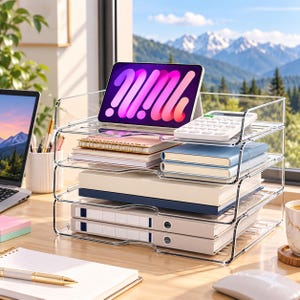 May include: A four-tier clear acrylic desk organizer holding a tablet displaying a purple and pink graphic, a white calculator, two spiral notebooks, two blue notebooks, a thick white book, and two light gray binders with white labels.