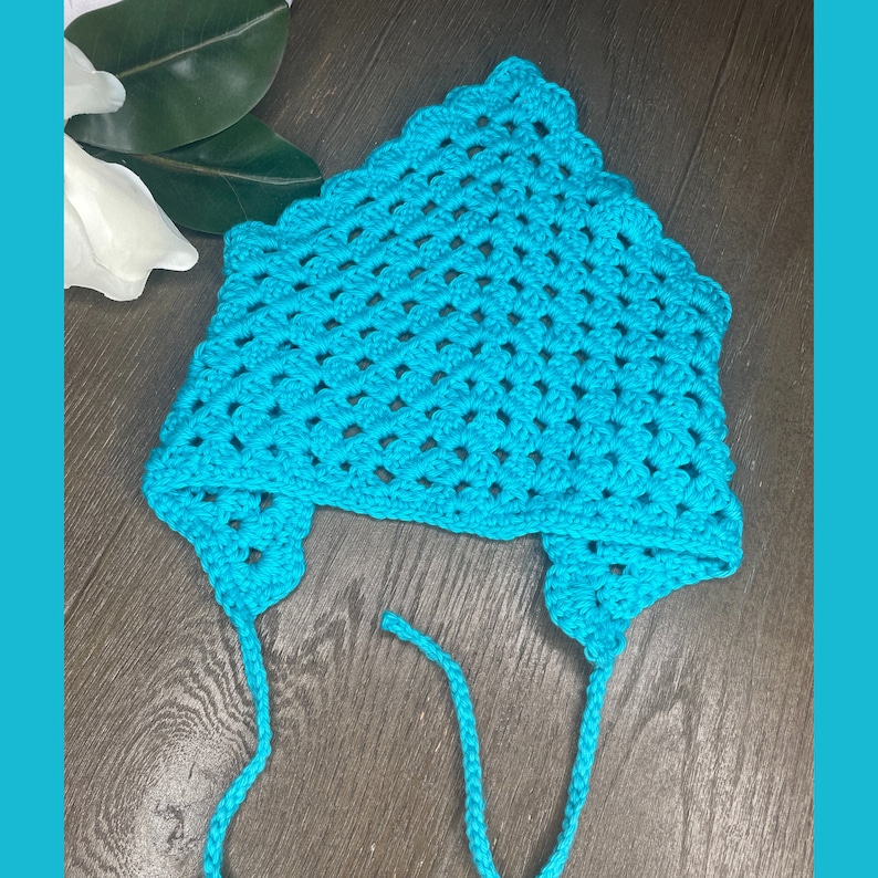 May include: A turquoise crocheted hat with a scalloped edge and two long ties. The hat is made with a simple stitch pattern and has a relaxed, casual look.