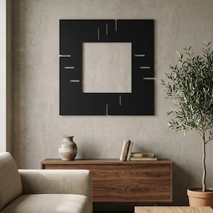 May include: A square black wall art piece featuring a central square cutout and various horizontal and vertical linear slits cut into the frame. The design is composed of a flat, matte black material with geometric negative space detailing.