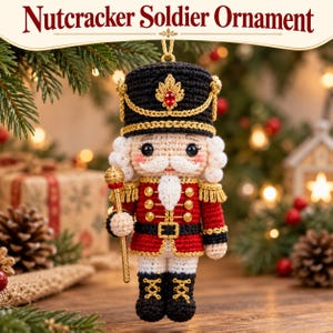 May include: A crocheted Nutcracker Soldier ornament featuring a black hat with a red gem, a red jacket with gold trim, white trousers, and black boots. The figure holds a gold staff and has white hair and a mustache. Text reads Nutcracker Soldier Ornament.