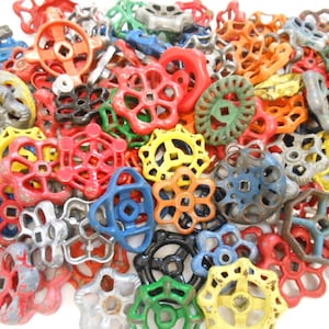 May include: A collection of vintage metal valve handles in various colors, including red, green, blue, yellow, and gray. The handles have a starburst design and are perfect for adding a touch of industrial charm to any project.