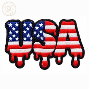May include: An embroidered patch featuring the letters USA in a dripping font style. The design incorporates the American flag pattern with a blue field of white stars on the letter U and red and white horizontal stripes across all three letters.
