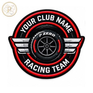 Puede incluir: Un parche bordado circular que presenta un neumático de carreras negro con una llanta plateada en el centro. El texto "YOUR CLUB NAME" está arqueado en la parte superior y "RACING TEAM" en la parte inferior en blanco. Alas plateadas se extienden a los lados, todo bordeado de rojo.