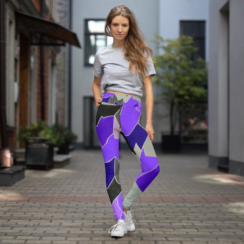 May include: Purple, black, and gray patterned leggings with a high waist. The leggings are made of a stretchy, comfortable fabric.