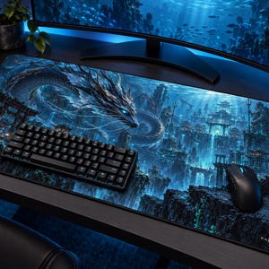 Peut inclure: Un tapis de bureau rectangulaire présentant une illustration détaillée en bleu et noir d'un long dragon serpentin nageant à travers une cité sous-marine avec une architecture en pierre et des lumières. La marque KAZENRI est imprimée en bas à droite.