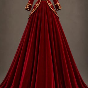 Peut inclure: Une robe longue en velours rouge profond dotée d'un corsage d'inspiration militaire avec un col montant, des galons dorés, des boutons dorés décoratifs et des épaulettes à franges dorées sur les épaules. Les manches longues ont des poignets dorés.