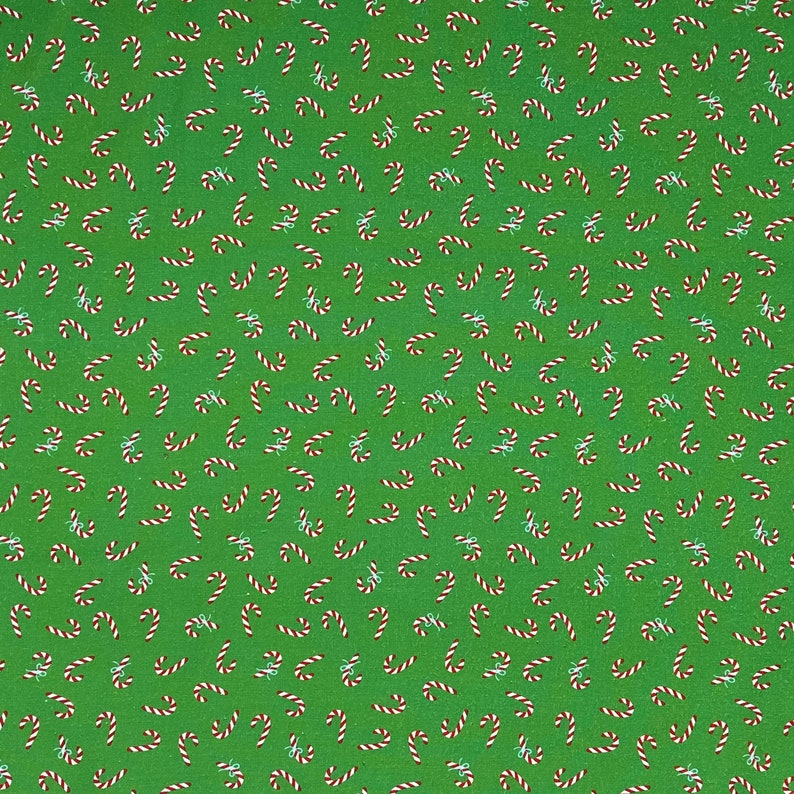Pode incluir: Um fundo verde com um padr&atilde;o repetido de bengalas de doces vermelhas e brancas. Cada bengala de doces &eacute; curva e listrada. Pequenos la&ccedil;os azuis claros est&atilde;o espalhados pelo design.