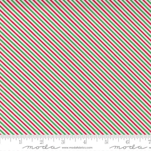 May include: White fabric featuring diagonal stripes in red and green. The stripes are evenly spaced, creating a festive pattern. A ruler at the bottom shows measurements in inches, equivalent to cm.