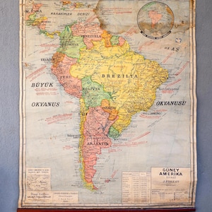 Könnte beinhalten: Vintage politische Karte von Südamerika mit türkischen Beschriftungen. Die Karte, montiert auf Holzstäben, zeigt die Geografie des Kontinents, einschließlich Länder, Städte und Ozeane.