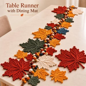 Pode incluir: Um caminho de mesa e um conjunto de jogos americanos com folhas de bordo em crochê nas cores vermelho, laranja, amarelo, verde e creme. O caminho inclui um fio de contas multicoloridas entre as folhas. Texto: Table Runner with Dining Mat.