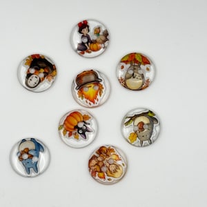 May include: A set of eight circular buttons featuring various colorful illustrations, including characters like Totoro, No-Face, and Calcifer, alongside autumn-themed elements such as pumpkins, acorns, and falling leaves.