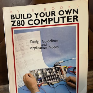 May include: A book titled "Build Your Own Z80 Computer" by Steve Ciarcia. The cover features a photo of a person working on a circuit board with wires and tools.