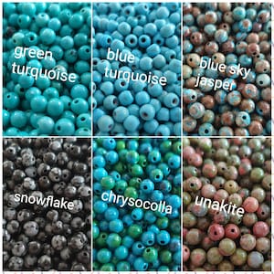May include: Assortment of round gemstone beads in various colors and patterns, including green turquoise, blue turquoise, blue sky jasper, snowflake obsidian, chrysocolla, and unakite.