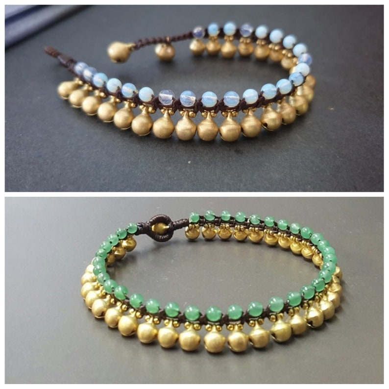 May include: Two anklets with gold beads and a brown cord. The top anklet has light blue beads and the bottom anklet has green beads.
