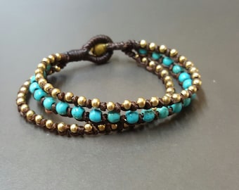 May include: A triple-wrap bracelet with brown cord and turquoise and gold beads.