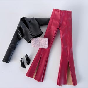 May include: A miniature fashion ensemble featuring a black faux leather jacket, a pair of red split-front trousers, a sparkly pink wrist cuff, and black heeled shoes. The outfit is designed for a doll or similar small figure.