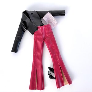 May include: A black faux leather jacket, red flared trousers with side slits, a pink scarf, and black heels are arranged on a white surface. The trousers have a high waist and flared legs.