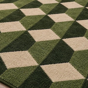 Puede incluir: Una alfombra texturizada con un patr&oacute;n geom&eacute;trico repetitivo de cubos tridimensionales. El dise&ntilde;o utiliza una paleta de colores de diamantes en verde bosque oscuro, verde oliva medio y color crema dispuestos para crear profundidad.